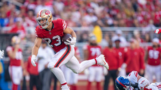 September 21, 2023; Santa Clara, California, USA; San Francisco 49ers running back Christian McCaffrey (23) runs past New York Giants linebacker Micah McFadden (41) during the second quarter at Levi's Stadium. Mandatory Credit: Kyle Terada-USA TODAY Sports